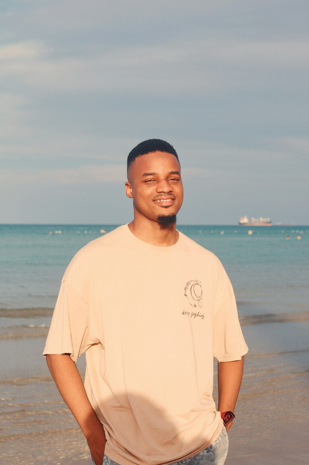 Smiling man with short dark hair in a beige t-shirt